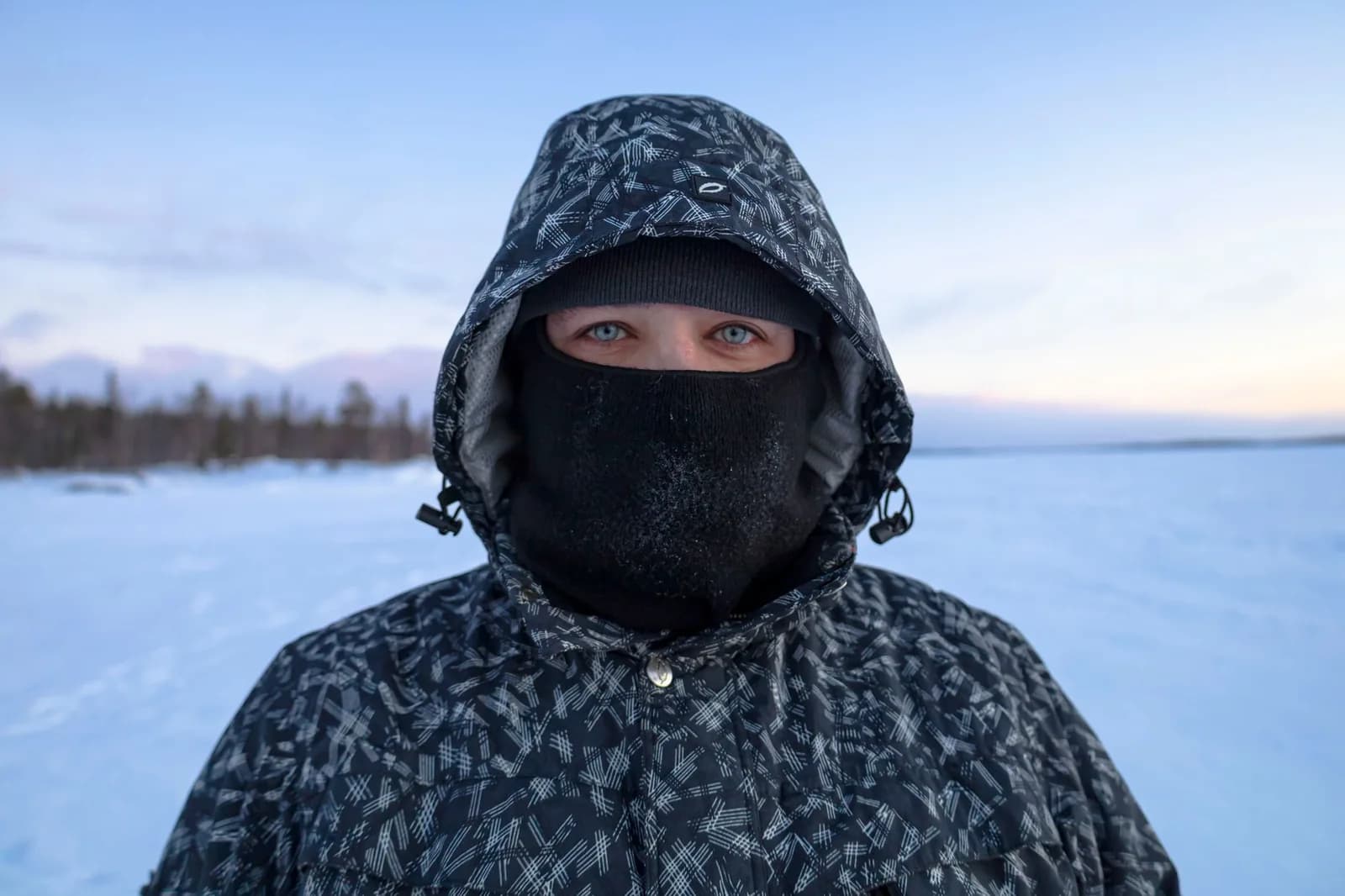 Personne équipée d'une parka à capuche et d'une cagoule givrée dans un paysage enneigé de Laponie